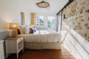 um quarto com uma cama e uma janela em Colombe - Une Maison du Pays d'Auge - Bain nordique em Le Mesnil-Eudes