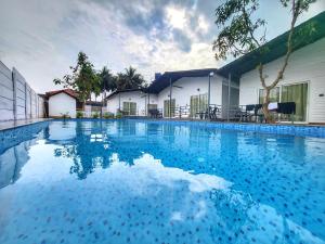 a large swimming pool in front of a building at Rashiva Resort in Arambol