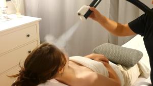 a woman laying in a bed with a blow dryer at Majątek Morgi in Suchowola