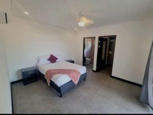 Un dormitorio con una cama con una manta rosa. en Castillo de Aslan. Casa nueva cerca de Playa Grande, en Huacas