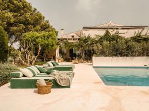 un divano verde accanto alla piscina di Hotel Rural Morvedra Nou a Ciutadella