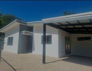 un gran edificio blanco con techo de metal en Castillo de Aslan. Casa nueva cerca de Playa Grande en Huacas