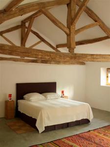 um quarto com uma grande cama branca e tectos em madeira em Le Pressoir - domaine du Chateau de La Bourlie - Boutique villa up to 12 guests em Urval