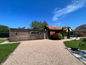 a house with a gravel driveway in front of it at Villa Louméa - Le Chalet avec jacuzzi in Friesenheim