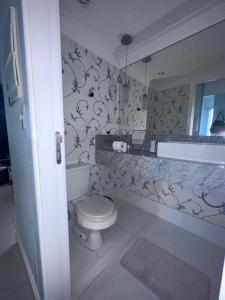 uma casa de banho com um WC branco e um lavatório. em Apartamento no Rio vermelho em Salvador