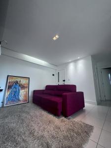 uma sala de estar com um sofá roxo e um tapete em Apartamento no Rio vermelho em Salvador