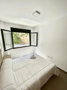 1 dormitorio blanco con 1 cama grande y ventana en Holiday apartment in Lucena del Cid Bajo B Ref 047, en Lucena del Cid