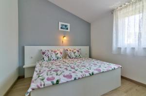 - une chambre blanche avec un lit orné de fleurs roses dans l'établissement MT SUN 115 App 2, à Selce