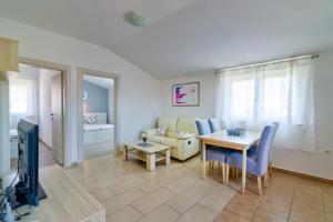 a living room with a table and a couch at MT SUN 115 App 2 by Aneo Travel in Selce