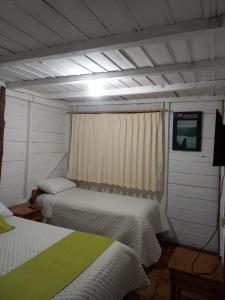 a room with two beds and a television in it at Finca La Esperanza in Palora