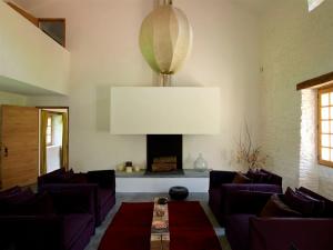 uma sala de estar com sofás roxos e uma lareira em Le Pressoir - domaine du Chateau de La Bourlie - Boutique villa up to 12 guests em Urval