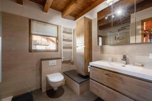 a bathroom with a toilet and a sink and a mirror at Chalet de vacances Les Contamines-Montjoie in Les Contamines-Montjoie