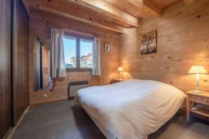 a bedroom with a large bed and a window at Chalet de vacances Les Contamines-Montjoie in Les Contamines-Montjoie