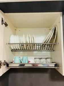 a kitchen cabinet with plates and dishes on shelves at Luxury Loft - 20th Floor / River View in Noida