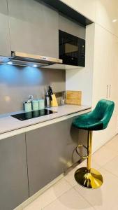 a green stool in a kitchen with a counter at Luxury Loft - 20th Floor / River View in Noida