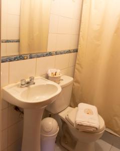 a bathroom with a sink and a toilet and a mirror at Alegrias Inn Hotel in Cusco