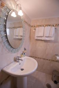 uma casa de banho com lavatório, espelho e toalhas em Hotel Urania em Preveza
