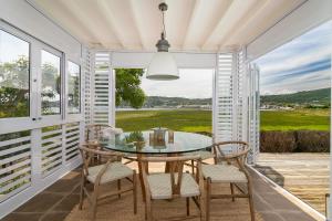 a dining room with a glass table and chairs at Sunset Lane Fairmile Point in Knysna