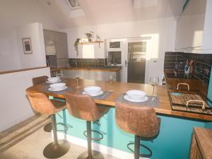 a kitchen with a wooden table with chairs and wine glasses at Cleddau Sound in Milford Haven