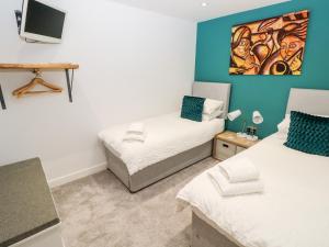 a bedroom with two beds and a tv on the wall at Cleddau Sound in Milford Haven