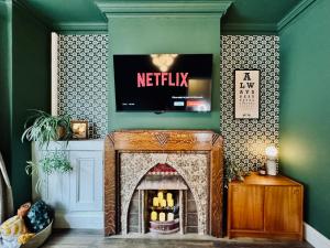 a living room with a fireplace with a tv above it at 3 Bed House, Sleeps 7, Free Parking, City Luxury, Central, Perfect for Contractors & Families! in Leicester