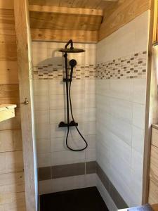 a shower in a wooden room with a shower at Cabane des Vargottes : insolite en pleine nature in Girmont-Val-dʼAjol