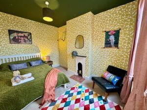 a bedroom with a green bed and a fireplace at Merton Retreat - City Luxury, Free Parking, Central, Sleeps 8 in Leicester
