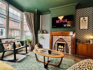 a living room with a table and a fireplace at 3 Bed House, Sleeps 7, Free Parking, City Luxury, Central, Perfect for Contractors & Families! in Leicester +54 photos