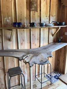 a wooden wall with a table with two bar stools at Cabane des Vargottes : insolite en pleine nature in Girmont-Val-dʼAjol