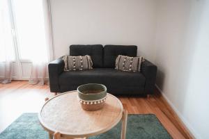 a living room with a black couch and a table at Le Cosmic Bliss • Chic Urbain au cœur du Berry in Châteauroux