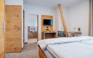 een slaapkamer met een bed, een bureau en een televisie bij Gasthaus Alte Post in Kirchzarten