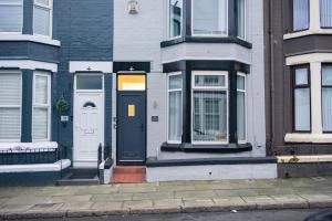 a white house with a black door on a street at Rooms with Netflix in a shared accommodation, 10 min walk from the stadium in Liverpool