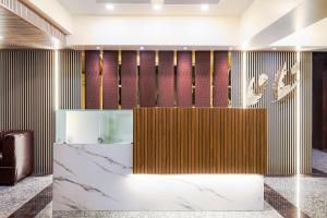 a hotel lobby with a marble counter and gold stripes at Treebo Trend A1 Residency - Hingna T Point in Nagpur