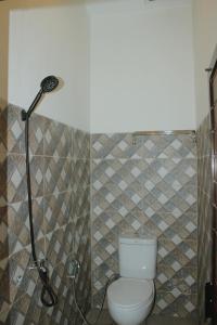 uma casa de banho com um WC e um chuveiro em Tiga Mahkota homestay em Diyeng