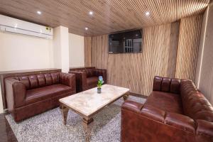 sala de estar con mesa y muebles de cuero marrón en Treebo Trend A1 Residency - Hingna T Point, en Nagpur