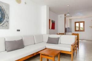 uma sala de estar com um sofá branco e uma mesa em Mar Brava Apartments em Can Picafort