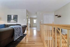 een woonkamer met een bank en een trap bij Home in Central Moncton WFH NBCC in Moncton