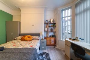 a bedroom with a bed and a desk and a window at Rooms with Netflix in a shared accommodation, 10 min walk from the stadium in Liverpool