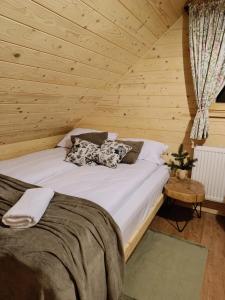 a bed in a room with a wooden ceiling at Domek we wsi, Pieniny, Jezioro Czorsztyńskie in Krośnica