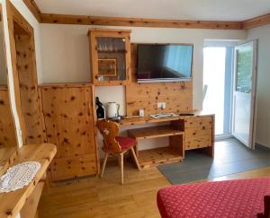 a home office with a desk and a tv at Nebenhaus Sagritzerwirt in Großkirchheim