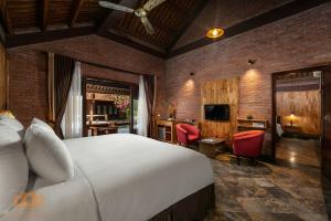 a bedroom with a bed and a desk and a television at Asean Resort - Shiki Onsen & Spa in Hanoi