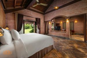 a bedroom with a large white bed and a tv at Asean Resort - Shiki Onsen & Spa in Hanoi
