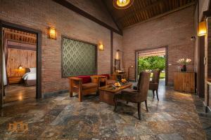 a room with a bed and a desk and chairs at Asean Resort - Shiki Onsen & Spa in Hanoi