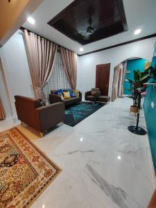 萬捷的住宿－Homestay Umar Homestay Tilam Hotel，客厅配有两张沙发和一张沙发
