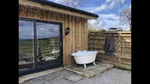 a bath tub sitting next to a building with a window at Springwood cabin 