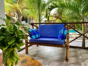 a blue chair on a patio with palm trees at CeZeRe THE PALM HOTEL in Paje