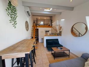 Le Côté Lub في بيرتويس: مطبخ وغرفة معيشة مع طاولة وأريكة
