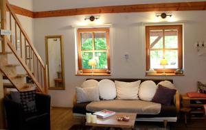 ein Wohnzimmer mit einer Couch und zwei Fenstern in der Unterkunft Kraut & Ruabn - Stadl in Engabrunn