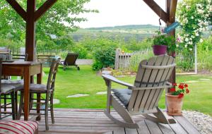 a deck with chairs and a table and a table and chairs at Kraut & Ruabn - Stadl in Engabrunn