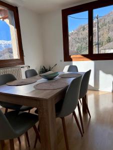 a dining room table with chairs and a table with a view at Appartement au cœur des alpes in Albertville